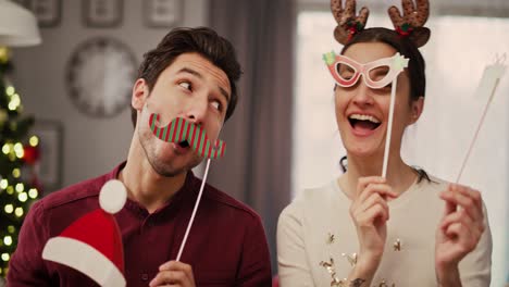 Handheld-view-of-playful-couple-in-Christmas-masks