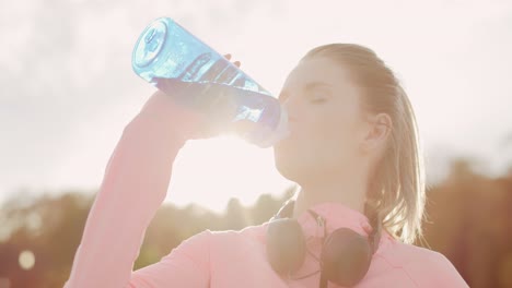 Handheld-view-of-woman-drinking-water-after-hard-workout