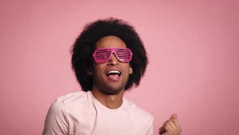 Junger-Afrikanischer-Mann-Lächelt-Und-Tanzt-In-Der-Rosa-Brille