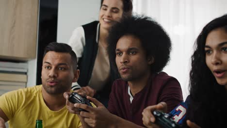 Tilt-up-video-of-excited-friends-playing-on-game-console