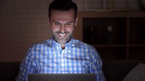 Man-with-laptop-during-video-conference-at-night