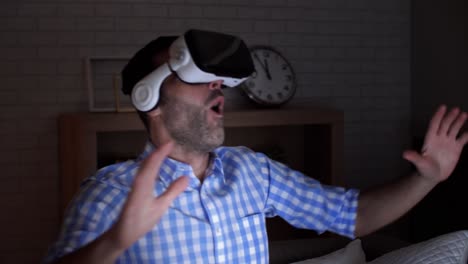 Excited-man-examining-virtual-reality-glasses-at-night