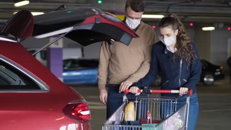 Video-of-couple-packing-groceries-into-a-car-during-a-pandemic