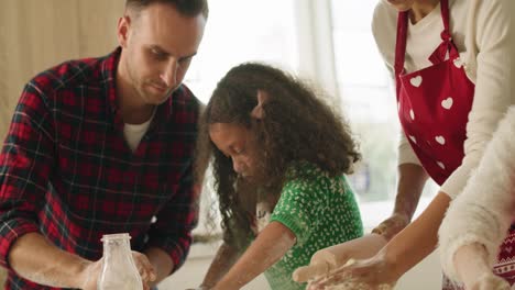 Handheld-view-of-children-baking-cookies-with-help-of-parents