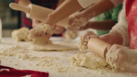 Handheld-view-of-family-rolling-the-dough-for-Christmas-cookies