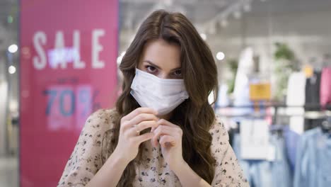 Video-portrait-of-young-woman-putting-on-a-protective-mask
