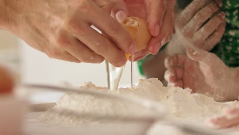 Handheld-view-of-egg-falling-into-flour