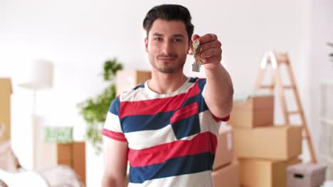 Young-man-holding-key-ring-to-his-new-house