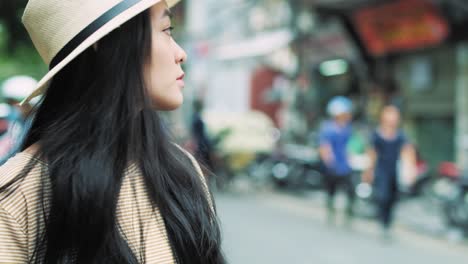 Handheld-view-of-Vietnamese-woman-with-mobile-phone-waiting-for-taxi