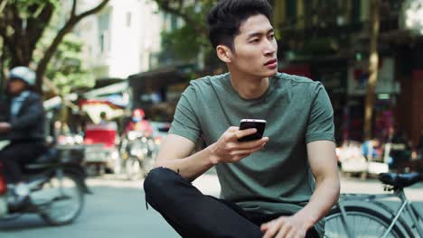 Handheld-Ansicht-Eines-Jungen-Vietnamesischen-Mannes,-Der-Sein-Mobiltelefon-Benutzt