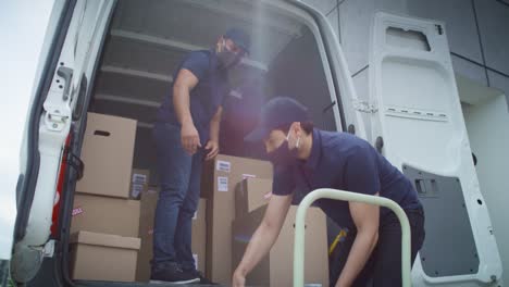 Video-of-two-couriers-in-protective-masks-unloading-packages