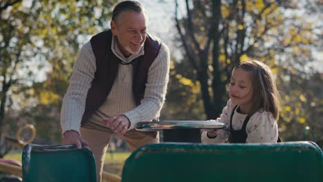 Caucasian-grandfather-playing-with-his-granddaughter-in-park