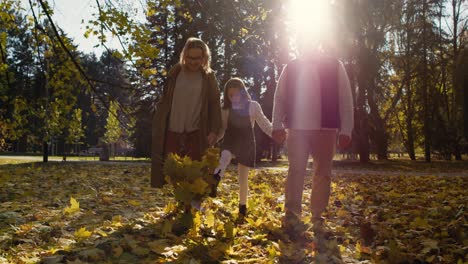 Senior-caucasian-couple-with-granddaughter-walking-in-park-together.