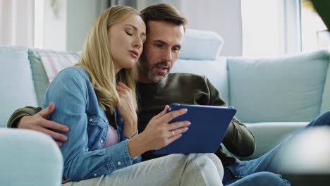 Loving-couple-using-a-tablet-in-living-room