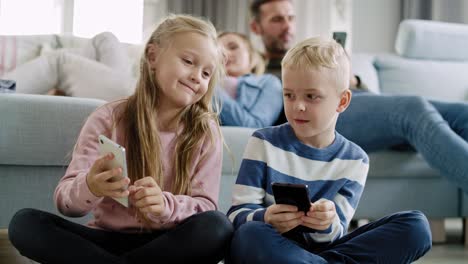 Handheld-Ansicht-Von-Kindern,-Die-Im-Wohnzimmer-Ihr-Mobiltelefon-Benutzen