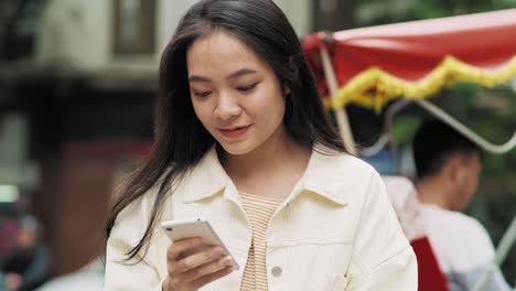 Handheld-Ansicht-Einer-Fröhlichen-Vietnamesischen-Frau-Mit-Mobiltelefon