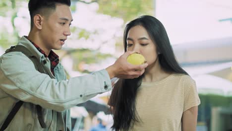 Handheld-view-of-vietnamese-couple-choosing-fruit-at-the-market
