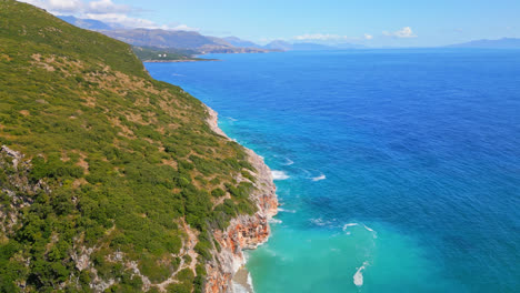 Aerial-drone-top-down-shot-over-mountain-slope-along-coastline-in-Albania-on-a-sunny-day