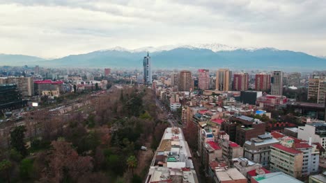Drone-establishing-shot-over-Lastarria-neighborhood-and-Forestal-park-on-a-cloudy-morning,-Telefonica-tower-in-Santiago-Chile