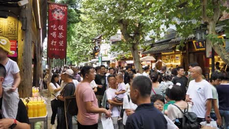 Daytime-capture-of-crowd-at-pedestrian-area-of-Chengdu's-Kuanzhai-Alley,-vibrant-street-vendors-and-artisan-shops-selling-handicrafts-and-traditional-trinkets-add-to-the-area's-lively-ambiance