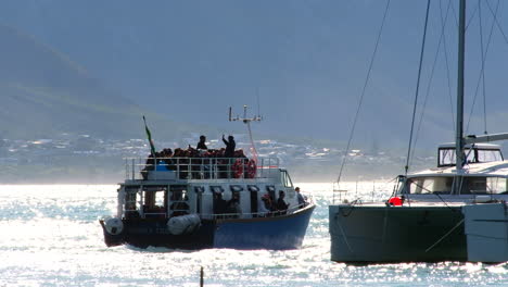 Whale-watching-boat-heading-out-on-ecotourism-excursion-with-tourists,-Hermanus