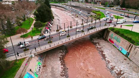 Fly-over-a-bridge-connecting-the-city-of-Santiago-Chile-with-the-brown-colored-Mapocho-river-and-high-vehicular-flow