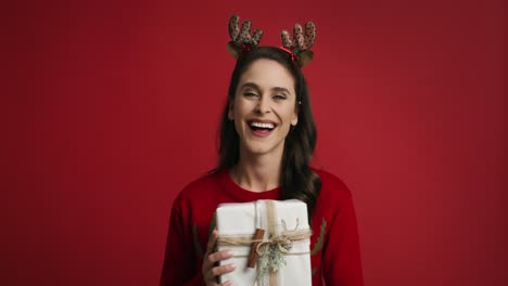Woman-with-Christmas-present-on-red-background