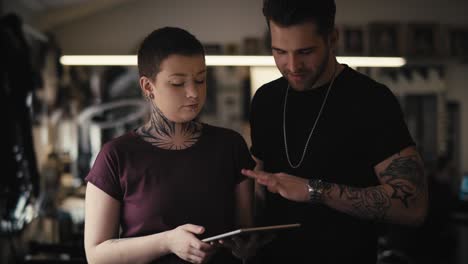 Two-caucasian-people-with-tattoo-discussion-about-new-project.