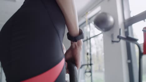 Handheld-view-of-female-athlete-with-kettlebell-exercising-at-gym