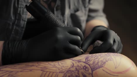 Close-up-of-tattoo-artist-drawing-on-arm-of-client.