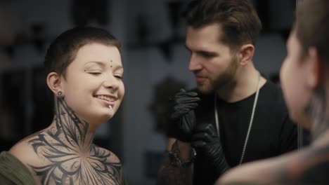 Caucasian-man-and-woman-checking-what-the-tattoo-looks-like-after-the-tattooing.