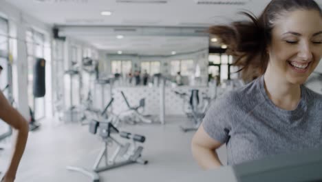 Handheld-view-of-young-women-running-on-the-treadmill-at-gym
