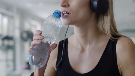 Handheld-view-of-female-athlete-drinking-water-after-hard-workout