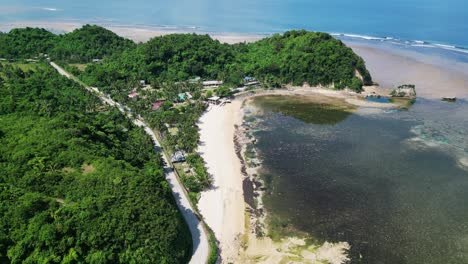 Aerial-view-of-scenic-Twin-Rock-Beach-Resort-with-white-sand-beach-and-lush-jungles-in-Virac,-Catanduanes