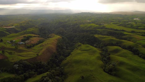 Green-Colombian-Meadow-Hills-with-Mixed-Weather-and-Distant-Rain-Storm,-Aerial
