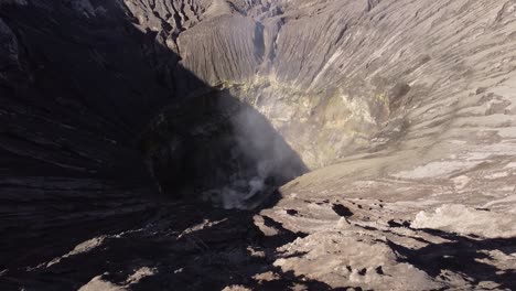 Aerial-crane-view-of-hot-steam-coming-from-the-Bromo-Volcano-crater,-Indonesia-volcanic-landscape