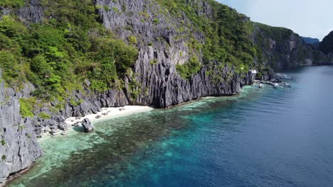 Tropical-water-and-white-sand-Beaches-between-limestone-mountains-on-Matinloc-Island,-El-Nido-palawan,-Philippines