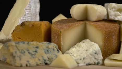 Close-up-low-angle-narrow-focus-cheese-assortment-rotating-on-board