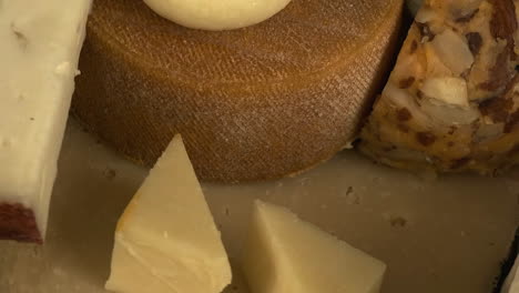 Macro-narrow-focus-closeup-view-of-various-cheeses-on-plate-rotating