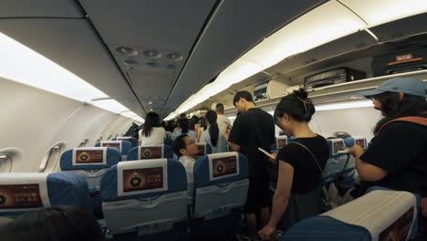 Asiatische-Passagiere-Stehen-Im-Gang-Des-Flugzeugs-Und-Warten-Auf-Die-Ausschiffung