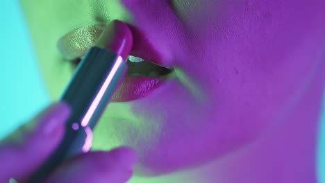 Static-close-up-of-beautiful-full-woman-lips-while-she-applies-red-lipstick-and-gets-ready-for-evening,-club-night-or-date-with-green-purple-contrast-in-her-face