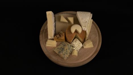 Several-kinds-of-delicious-cheese-rotate-on-wooden-cutting-board
