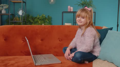 Fröhliches-Schulmädchen-Benutzt-Laptop-Computer-Und-Lernt-Allein-Zu-Hause-Das-Lesen-Von-Online-Unterrichtsstunden