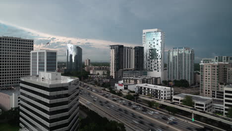 Time-lapse-of-busy-traffic-and-downtown-buildings-and-dark-rain-clouds,-Houston-Texas