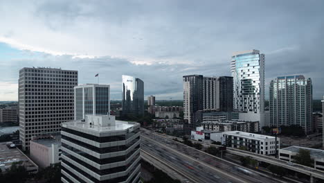 Time-lapse-of-busy-traffic-and-downtown-buildings-and-dark-rain-clouds,-Houston-Texas,-wide-shot
