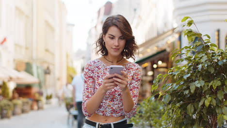 Glückliche-Frau-Nutzt-Ihr-Mobiles-Smartphone-Und-Feiert-Den-Gewinn-Guter-Nachrichten-Im-Freien-In-Der-Stadtstraße