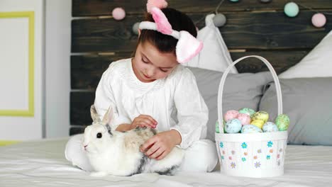 Child-and-her-rabbit-celebrating-Easter-in-bed