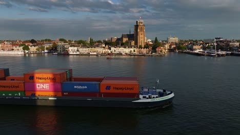 Backdrop-of-Dordrecht-a-container-ship-full-of-goods-sails-on-the-Oude-Maas-river