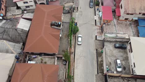 Aeriel-Shot-of-a-quiet-neighbourhood-with-cars-parked-on-the-street-and-in-compounds-with-birds-flying-past
