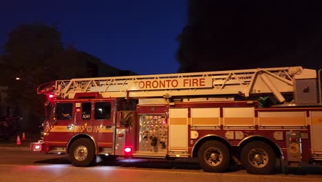 Toronto-Fire-truck-flashes-lights-and-rushes-away-from-smoky-building-scene-down-road